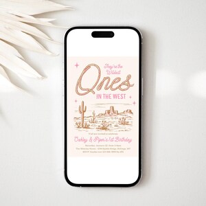 Peut inclure: Un smartphone affiche une invitation sur le th&egrave;me du d&eacute;sert. Le texte se lit &laquo; They're the Wildest Ones in the West &raquo; avec une police de style corde. L'invitation comprend une illustration de paysage d&eacute;sertique avec des cactus et des mesas. L'invitation est pour le 1er anniversaire d'Oakley et Piper.