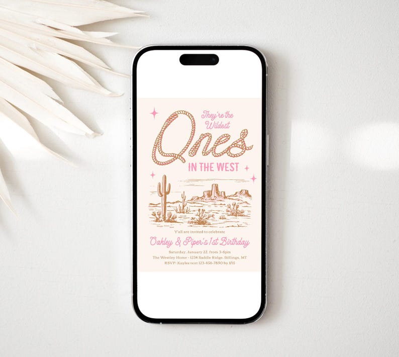 Peut inclure: Un smartphone affiche une invitation sur le th&egrave;me du d&eacute;sert. Le texte se lit &laquo; They're the Wildest Ones in the West &raquo; avec une police de style corde. L'invitation comprend une illustration de paysage d&eacute;sertique avec des cactus et des mesas. L'invitation est pour le 1er anniversaire d'Oakley et Piper.