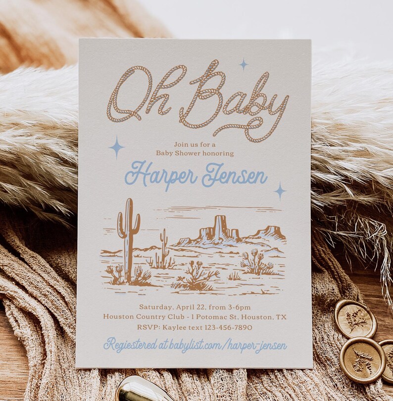 May include: A light beige baby shower invitation with a brown rope design that says "Oh Baby" in cursive. The invitation also includes a desert landscape illustration with cacti and mountains. The text on the invitation reads "Join us for a Baby Shower honoring Harper Jensen. Saturday, April 22, from 3-6pm Houston Country Club - 1 Potomac St. Houston, TX RSVP: Kaylee text 123-456-7890 Registered at babylist.com/harper-jensen"