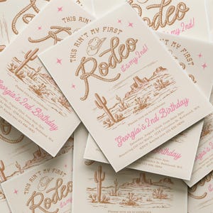 May include: A stack of rectangular birthday invitations on cream cardstock featuring brown line art of a desert landscape, a cowboy hat, and rope lettering that reads "THIS AIN'T MY FIRST Rodeo it's my 2nd!" with pink text "Georgia's 2nd Birthday".