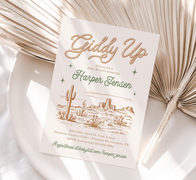 May include: A baby shower invitation with a western theme. The invitation features a drawing of a desert landscape with cacti and mountains. The text on the invitation reads "Giddy Up" and "Join us for a Baby Shower honouring Harper Jensen".