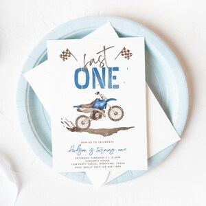 May include: A blue and brown birthday party invitation with a watercolor illustration of a dirt bike. The text reads "Fast One" and "Hudson is turning one". The invitation includes the date, time, location, and RSVP information.
