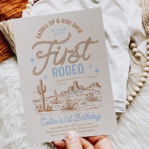 May include: A light blue and brown invitation with a rope design that says "Saddle Up & Ride Over It's Our Boy's First Rodeo". The invitation is for a first birthday party and includes the text "Cotter's 1st Birthday", the date, time, location, and RSVP information.