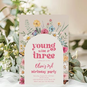 May include: A pink and white floral birthday party invitation with the text "young wild & three" and "Olive's 3rd birthday party". The invitation has a floral border and a white circle with the text in the center.