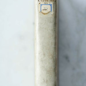 May include: A vintage book with a white cover and brown text that reads "van MIERIS over de Munten en Zegelen v. Utrecht."