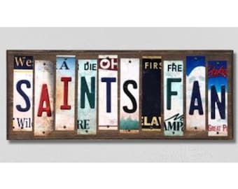 May include: A wooden sign with the words "Saints Fan" spelled out using vintage licence plates. The plates are in various colours and have different state names and numbers on them.