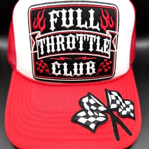 May include: A red and white trucker hat featuring a rectangular embroidered patch on the front with the text FULL THROTTLE CLUB in white letters, red flame accents, and checkered patterns. A pair of crossed checkered racing flags is on the brim.