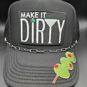 May include: Black trucker hat with a mesh back and a curved brim. The front features a patch with the words "MAKE IT DIRTY" and a martini glass graphic. A chain detail accents the brim, and embroidered olives are on the side.