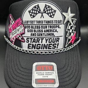 May include: A black trucker hat featuring a white patch with checkered flags and the text: JUST GOT THREE THINGS TO SAY: GOD BLESS OUR TROOPS, GOD BLESS AMERICA, AND GENTLEMEN, START YOUR ENGINES! It includes a silver chain, star patches, and an OTTO label.