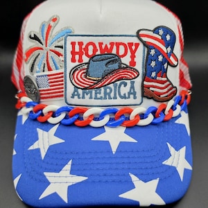 May include: A white ceramic mug with a black handle and the text "But First, Coffee" in a bold, black font. The mug is set against a blurred background, suggesting a cozy setting.