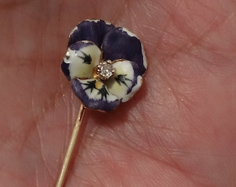 以下が含まれることがあります： 中央にダイヤモンドが1つ付いた、紫と白のエナメルでできた花がついた金のピン