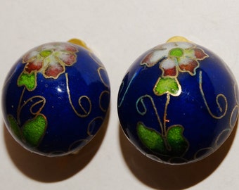 May include: A pair of blue enamel earrings with gold accents and floral designs. The earrings are round and have a white, red, and green floral pattern.