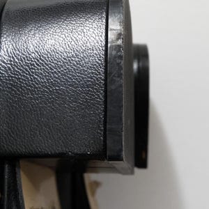 May include: Close-up of the black leather heel of a shoe. The heel is smooth and has a slight sheen.