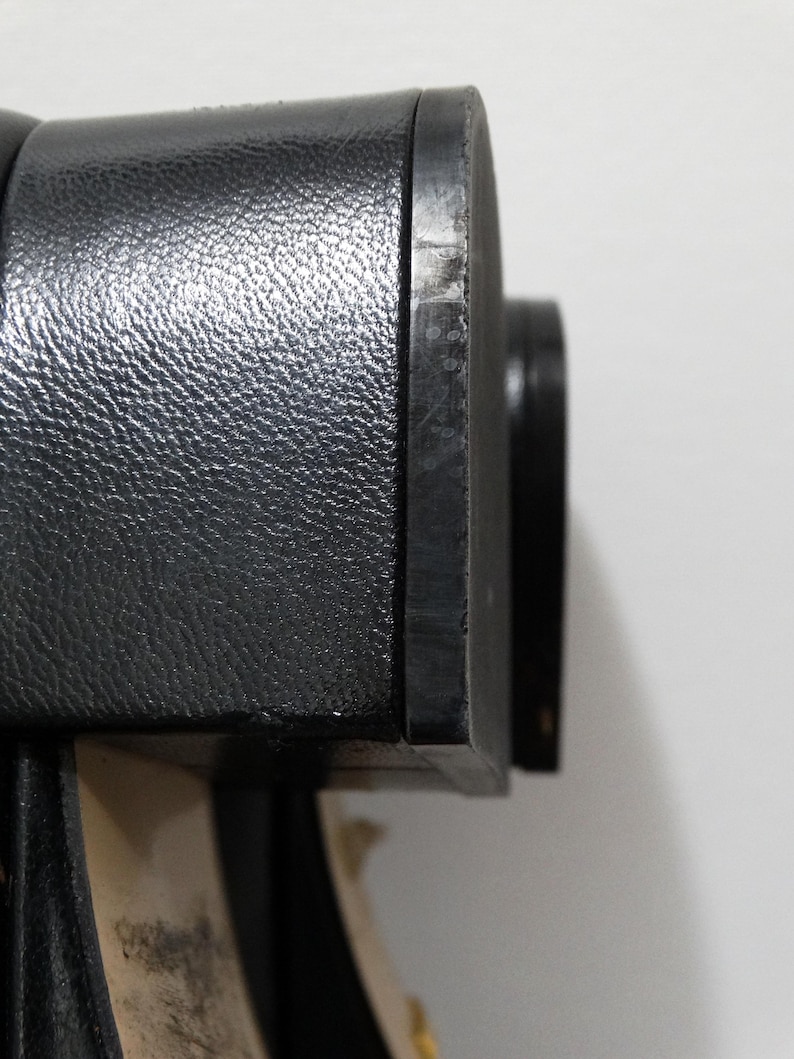 May include: Close-up of the black leather heel of a shoe. The heel is smooth and has a slight sheen.