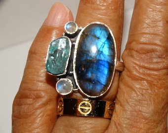 May include: A silver ring with a large blue labradorite gemstone, a smaller aquamarine gemstone, and two smaller moonstone gemstones.