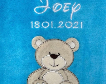 Puede incluir: Una manta de bebé azul claro con un oso de peluche bordado en blanco y el nombre "Joep" y la fecha "18.01.2021".