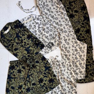 May include: An assortment of floral-patterned sleepwear in various styles and colors. The collection includes shorts, pants, and long-sleeved shirts in olive green, black, and cream. Some pieces feature a monogram.