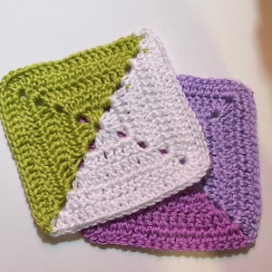May include: Three crocheted squares in green, white, and purple. The squares are layered on top of each other.