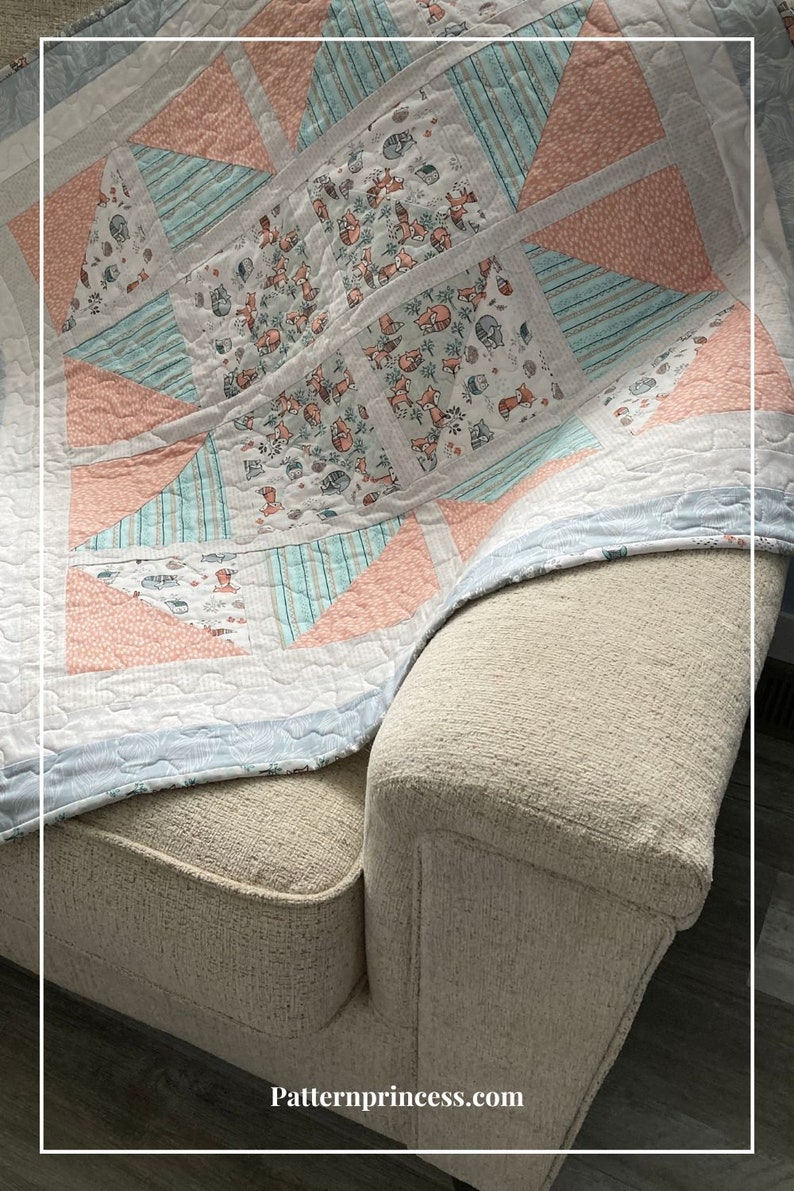 Puede incluir: Una colcha azul claro y rosa con un estampado de zorros. La colcha est&aacute; doblada y drapeada sobre un sof&aacute; beige. El texto "Patternprincess.com" es visible en la esquina inferior derecha de la imagen.