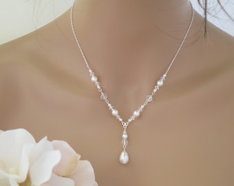 May include: A silver necklace with a teardrop-shaped pearl pendant and small white pearls and clear crystals.