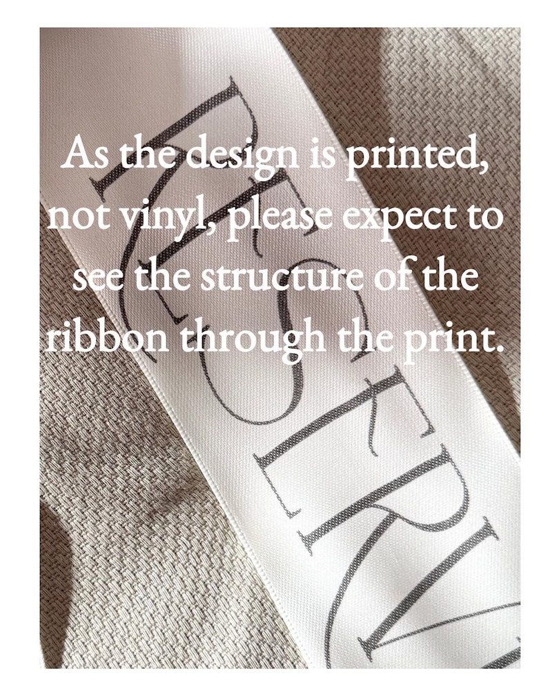 Puede incluir: Una cinta de sat&eacute;n blanca con texto impreso en negro que dice: As the design is printed, not vinyl, please expect to see the structure of the ribbon through the print. La cinta tiene una textura tejida visible y la palabra RESERVED es parcial.