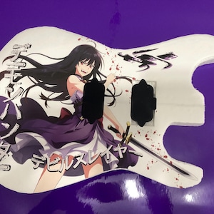 以下が含まれることがあります： 長い黒髪で紫と白のドレスを着て剣を持つアニメキャラクターがプリントされた白いエレキギターのボディ。デザインには日本語のテキストと赤い飛沫が含まれており、前面には2つの黒いピックアップが取り付けられています。