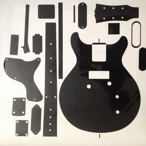 May include: A black and white guitar template with various parts, including the body, neck, pickguard, and control knobs.