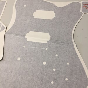 May include: A grey guitar body template with white circles and rectangular cutouts. The template is labelled "35 mm" and "SCALE".