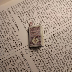 Miniatura domku dla lalek w skali 1,12, ilustrowana książka kucharska pani Beeton.