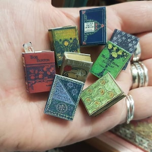 Réplique antique miniature à l'échelle 1,12, lot de 8 livres. Chaque livre contient des pages vierges tournantes vieillies. Un signet amovible est également inclus.