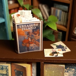 Libro d'epoca in miniatura di casa delle bambole in scala 1:12, Treasure Island illustrato. Sono inclusi anche un segnalibro sciolto e delle cartoline.