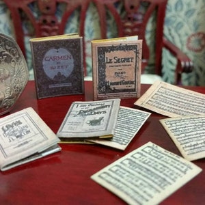 Antique replica set of music books and sheets in 1:12 scale that open with blank  pages inside.