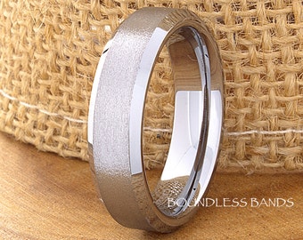 May include: A brushed silver tungsten carbide wedding band with a bevelled edge. The band is shown on a burlap background. Boundless Bands.