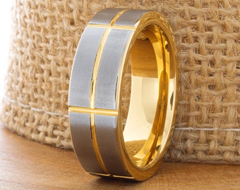 May include: A silver and gold wedding band with a brushed finish and a grooved design.