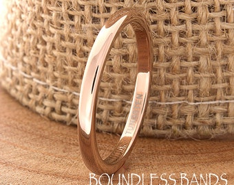 May include: A rose gold tungsten ring with a polished finish. The ring is engraved with the word "TUNGSTEN".