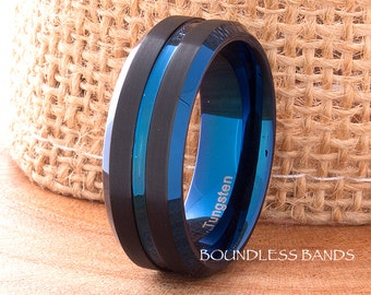 May include: A black and blue tungsten ring with a beveled edge and a polished finish. The ring is engraved with the word "Tungsten" and the words "Boundless Bands".