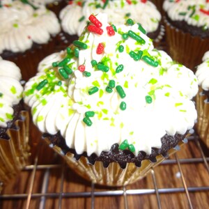 May include: Chocolate cupcakes frosted with white icing and decorated with green and red sprinkles.