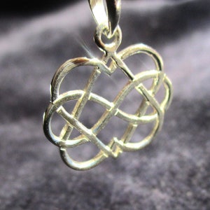 May include: A silver Celtic knot heart pendant charm. The pendant is in the shape of a heart with a knot design. The pendant is made of silver and has a shiny finish.