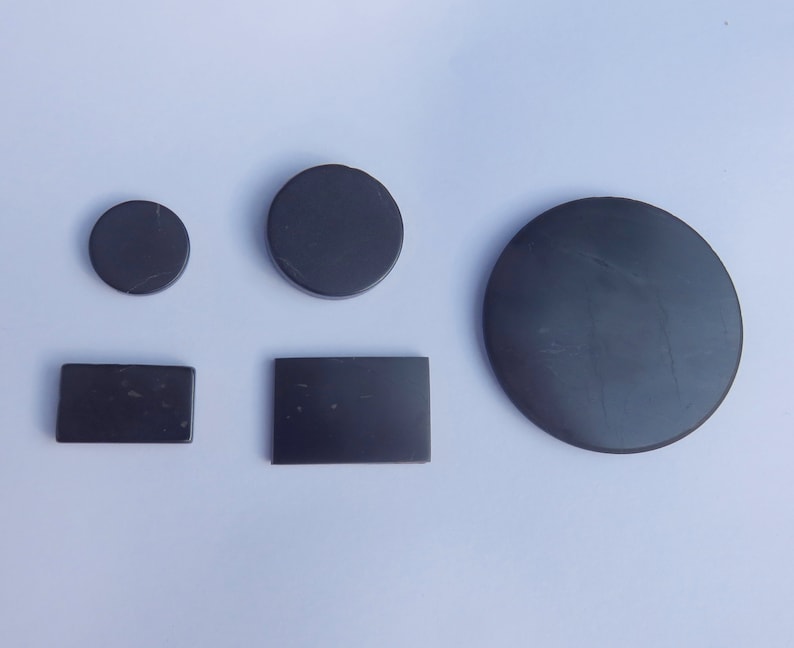 May include: Five black round and rectangular shaped magnets of various sizes.