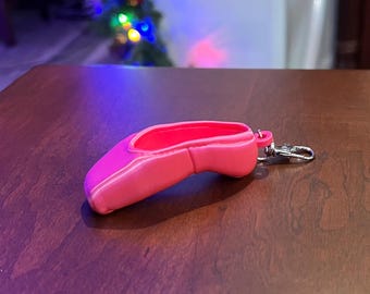 May include: A pink ballet shoe keychain with a silver metal ring.