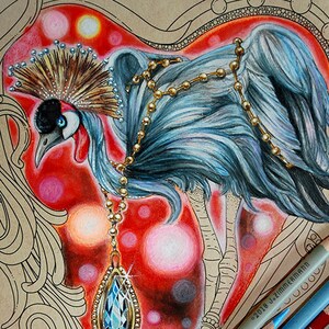 Może przedstawiać: Szczegółowy rysunek kredkami korony z naszyjnikiem ze złota i niebieską zawieszką z kamieniem szlachetnym na czerwonym i różowym tle w kształcie serca. Kilka kolorowych ołówków i biały długopis ułożone na dole.