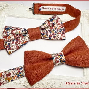 Op de afbeelding: Twee strikjes, een met een bloemenpatroon en een effen roestkleur. Beide strikjes zijn gemaakt van linnen en hebben een bijpassend verstelbaar bandje met hetzelfde patroon. Het bandje heeft de tekst "Fleurs de Provence" erop.