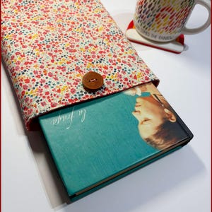 May include: A book cover with a floral pattern and a brown button. The book is titled "La Finada" and is resting on a white surface.