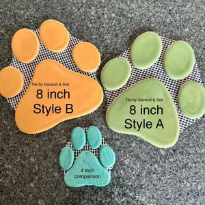 May include: Three paw print tiles in orange, green, and teal. The orange and green paw prints are 8 inches in size, while the teal paw print is 4 inches. The text "Tile by Gavazzi & Son" and "Style A" and "Style B" are visible.
