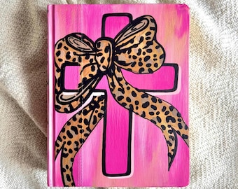 Biblia NIV pintada a mano en rosa con lazo de leopardo, ideal para diario.