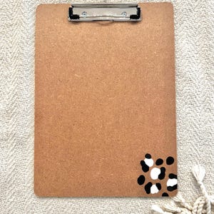 May include: A brown clipboard with a black and white leopard print design in the bottom right corner.