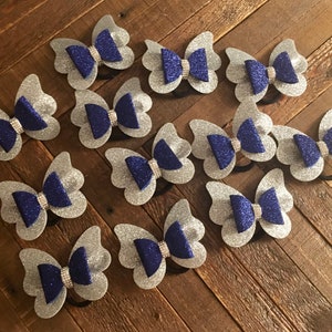 May include: Twelve silver and blue glitter butterfly hair bows with rhinestones.
