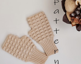 May include: A pair of beige crocheted fingerless gloves with a textured pattern. The gloves are laid out flat on a white surface. The word "Pattern" is written vertically in black letters on the right side of the image.