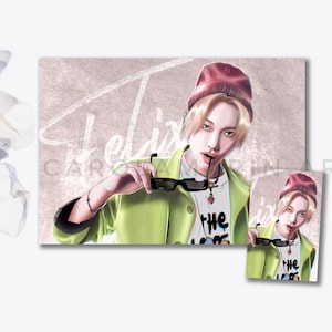 Puede incluir: Una ilustración digital de una persona con cabello rubio que lleva una boina roja, una chaqueta verde y gafas de sol. La persona está sosteniendo las gafas de sol en su mano y mirando a la cámara. El fondo es de color rosa claro con la palabra "Felix" escrita en blanco.