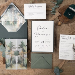 May include: A wedding invitation suite with a forest theme. The invitation features a watercolour illustration of trees and a green envelope. The RSVP card has a handwritten font and a black border. The text on the invitation reads "Together with their families, Padma and Harrison invite you to celebrate their marriage, October 21, 2023, Saturday 4:00 PM, The Barn at Countryside, Acorns, Oregon, Reception to Follow."